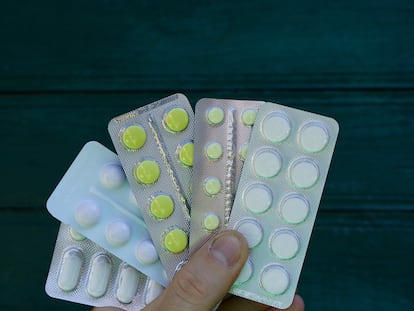 hand holds pills in packs on a green background