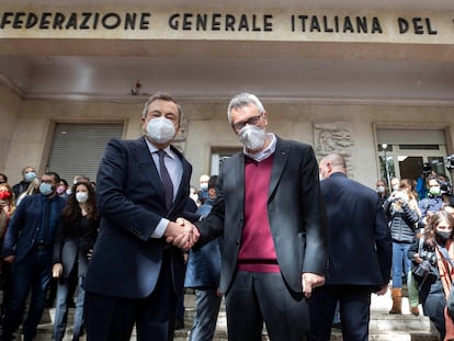 El primer ministro de Italia, Mario Draghi (izquierda), saluda este lunes al secretario general de CGIL, Maurizio Landini, frente a la sede en Roma del sindicato atacado este fin de semana por grupos fascistas.