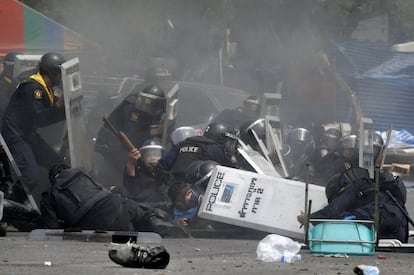 La policía tailandesa reacciona a la explosión de un artefacto lanzado por manifestantes opositores al gobierno, en Bangkok. Al menos tres policías resultaron heridos mientras las autoridades tailandesas lanzaron una operación para despejar a los manifestantes contra el gobierno de las calles de Bangkok. 