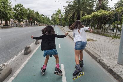 Duas crianças patinam em uma rua de Sevilha.