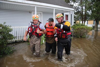 Miembros del equipo de rescate de Carolina del Norte ayudan a un residente a atravesar aguas inundadas en Lumberton.