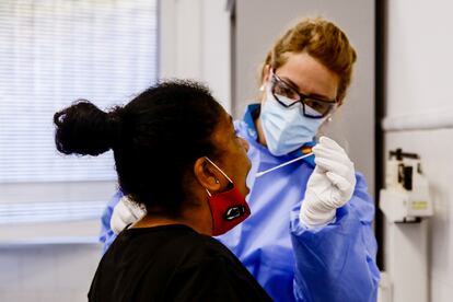 Una trabajadora sanitaria protegida realiza un test a una mujer.