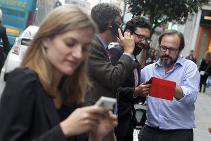 Varias personas usan sus dispositivos móviles en la Gran Vía de Madrid