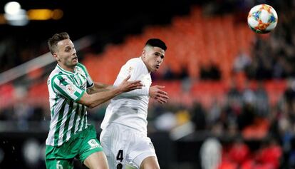 El defensa del Valencia, Facundo Roncaglia, y el mediapunta del Betis, Sergio Canales, lucha por hacerse con la posesión del balón.