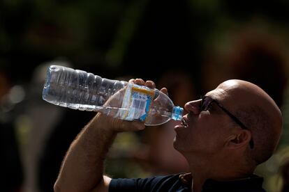 Un turista bebe agua mientras hace cola para entrar en el Palacio Real de Madrid, este lunes. 

