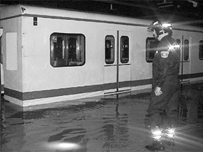 Un bombero observa la inundación registrada en los andenes de la estación de Antonio Machado tras la tromba de agua.
