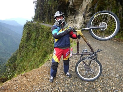 Un ciclista, ataviado con casco y protecciones, durante uno de los descensos organizados que algunas empresas de turismo activo organizan en el camino de Yungas, en Bolivia.