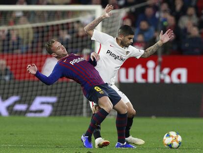 Arthur y Banega luchan por un balón.