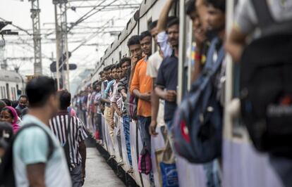 Pasajeros indios abarrotan un tren en una estacion ferroviaria en Calcuta (India), donde se celebra la jornada del Día Mundial de la Población.