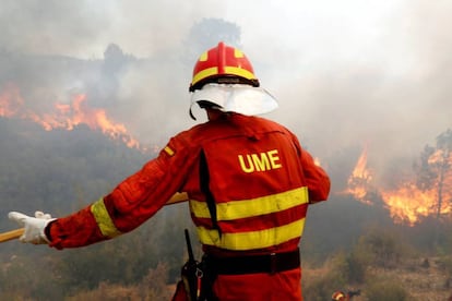 A firefighter tries to extinguish a forest fire in Llutxent.