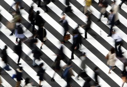 Gente cruzando por un paso de cebra en una calle de Tokio (Japón).