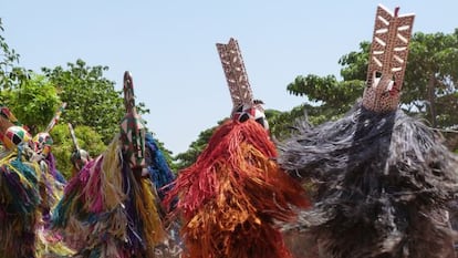 Bailarines con trajes de fibras tintadas y m&aacute;scaras de madera en el barrio de Kibide, en Bobo Dioulasso.