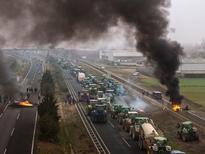 Agricultores montan barricadas tras bloquear la autopista cerca de Mollerussa, en Lleida, este martes.