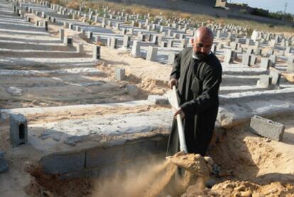 Un enterrador cava una tumba en Misrata (Libia) para una víctima civil, el pasado mes de abril.