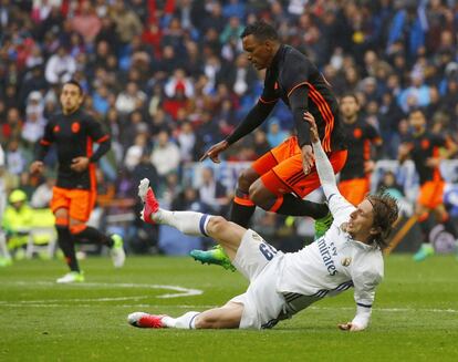 El centrocampista croata del Real Madrid Luka Modric (suelo) y el jugador portugués del Valencia Luis Nani.