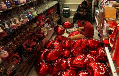 Un hombre infla globos con forma de corazón para San Valentín en Peshawar (Pakistán), el 7 de febrero de 2018.