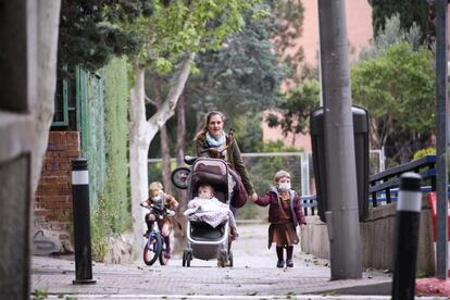 Uma mãe acompanhada de seus três filhos durante seu passeio, em Madri.