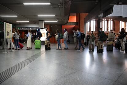 Viajeros en la estación de Atocha, a las 15.00 horas, cuando el Gobierno ya había anunciado el estado de alarma en Madrid y preparaba su entrada en vigor.