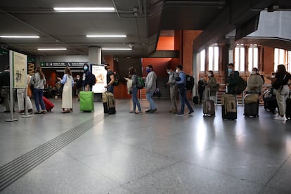 Passengers wait in line for a train at Madrid's Atocha station on Friday afternoon.