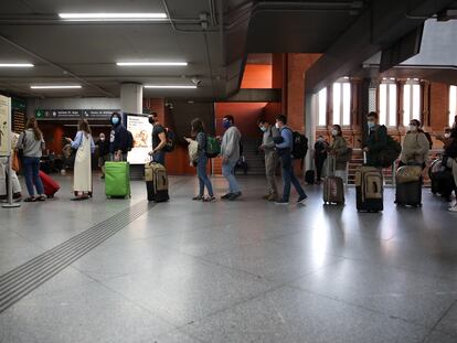 Viajeros en la estación de Atocha, a las 15.00 horas, cuando el Gobierno ya había anunciado el estado de alarma en Madrid y preparaba su entrada en vigor.