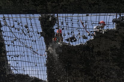 Un grupo de hombres trabaja para derribar lo que quedó del techo de la nave central del mercado La Merced tras el incendio de la noche del 24 de diciembre.