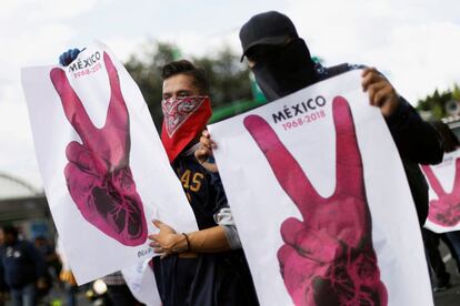 Dos jóvenes sostienen carteles durante la manifestación en recuerdo de la matanza de Tlatelolco, el 2 de octubre de 2018, en Ciudad de México. 