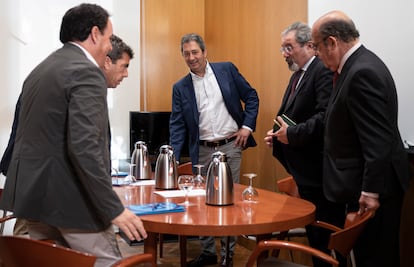 Carlos Mazón (segundo por la izquierda), Vicente Barrera (en el centro) y Carlos Flores (con perilla), durante una reunión de negociación entre el PP y Vox, el día 13 de junio.