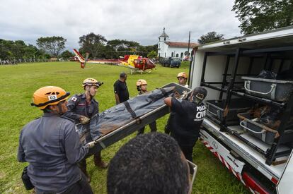 Bombeiros carregam um corpo recuperado em meio aos rejeitos em Brumadinho. 