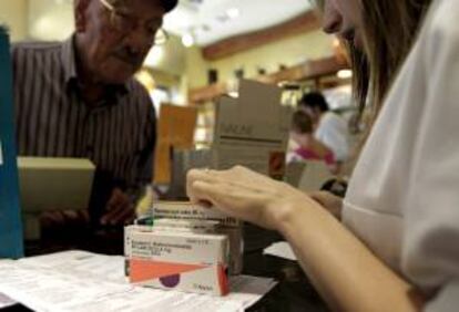 ESPAÑA CRISIS SANIDAD:NAC32. BARCELONA, 23/06/2012.- Un hombre adquiere hoy varios medicamentos en una farmacia de Barcelona, en el día en el que Cataluña inicia la experiencia de cobrar a los ciudadanos un euro por receta médica. EFE/Albert Olivé