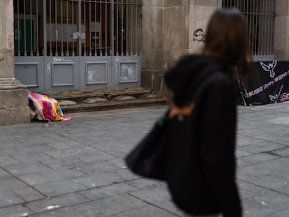 Una alumna observa la fachada de la Parroquia Immaculada Concepcio i Sant Llorenç donde han encontrado distintos elementos hostiles, aun así, hay gente durmiendo junto a la fachada.