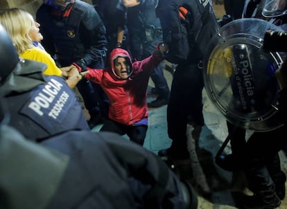 A woman is pulled away from the entrance to the regional Catalan parliament by Mossos officers.