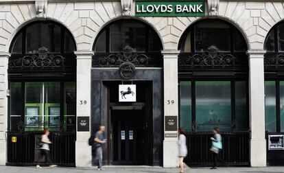 Varias personas ante la fachada de una oficina del banco Lloyds en Londres.