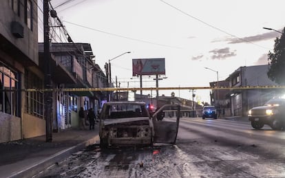 Policías acordonan la zona en donde se halló un vehículo incinerado en Tijuana, Baja California.