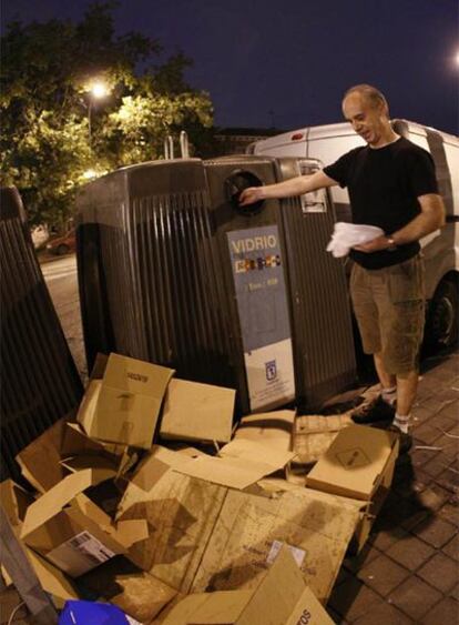 Un ciudadano recicla en un contenedor urbano.