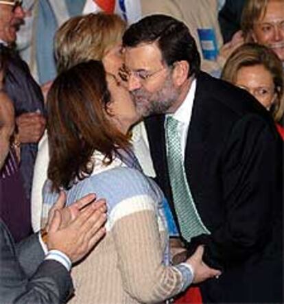 El candidato del PP, Mariano Rajoy, besa a una simpatizante durante un acto celebrado esta mañana en Oviedo.