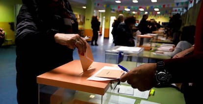 Varios electores depositan sobres con las papeletas en el CEIP Ortega y Gasset de Madrid. EFE/David Fernández