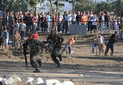 Familiares de los presos lanzan piedras contra los soldados que vigilan el interior del penal de Comayagua, ante la falta de información sobre lo sucedido dentro de la cárcel.