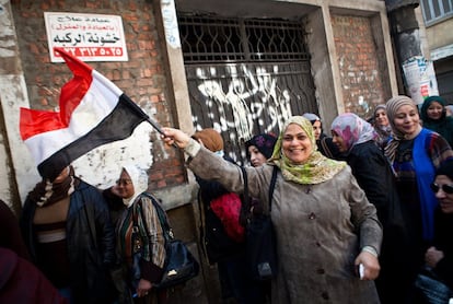 Una mujer con una bandera egipcia espera poder votar la nueva Constitución en Mounira, en El Cairo.