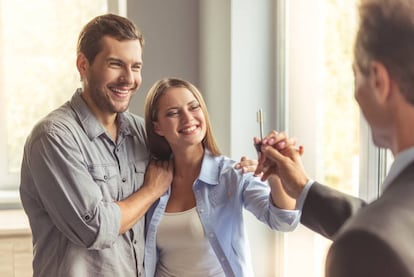 Una pareja recibe las llaves de su casa. GETTY