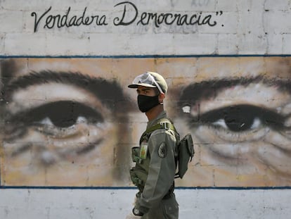 Un soldado custodia una escuela de Caracas en cuya pared tiene los ojos de Hugo Chávez, en las elecciones legislativas del 6 de diciembre pasado.