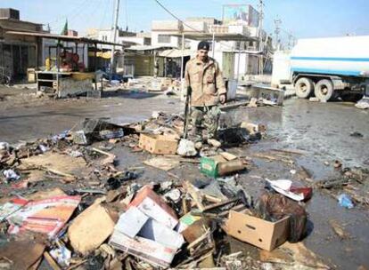 Un policía limpia la zona del mercado popular de Bagdad, donde una mujer suicida ha matado a 45 personas.