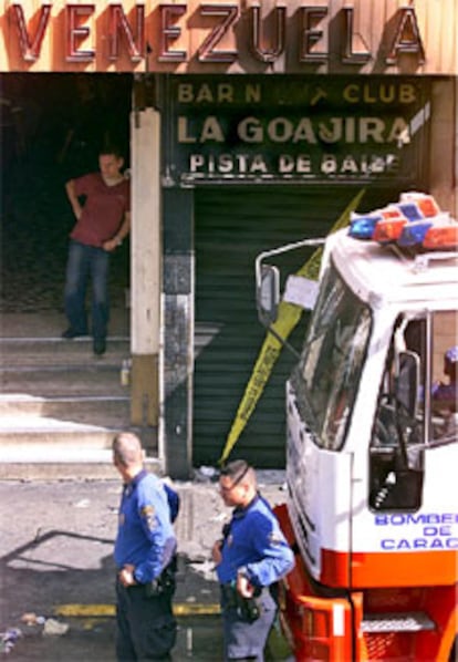 Los bomberos de Caracas, frente a la entrada de la discoteca incendiada.