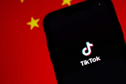 Móvil con TikTok y bandera de China detrás