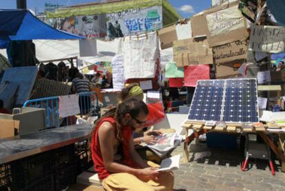 Dos de los concentrados leen, a la una de la tarde, en una de las casetas que conforman el campamento de Sol, junto a unas placas solares.