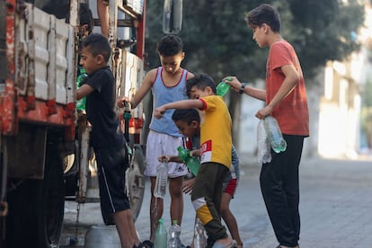 Un grupo de niños cogen agua de un camión cisterna situado en una calle de Rafah, este miércoles. 