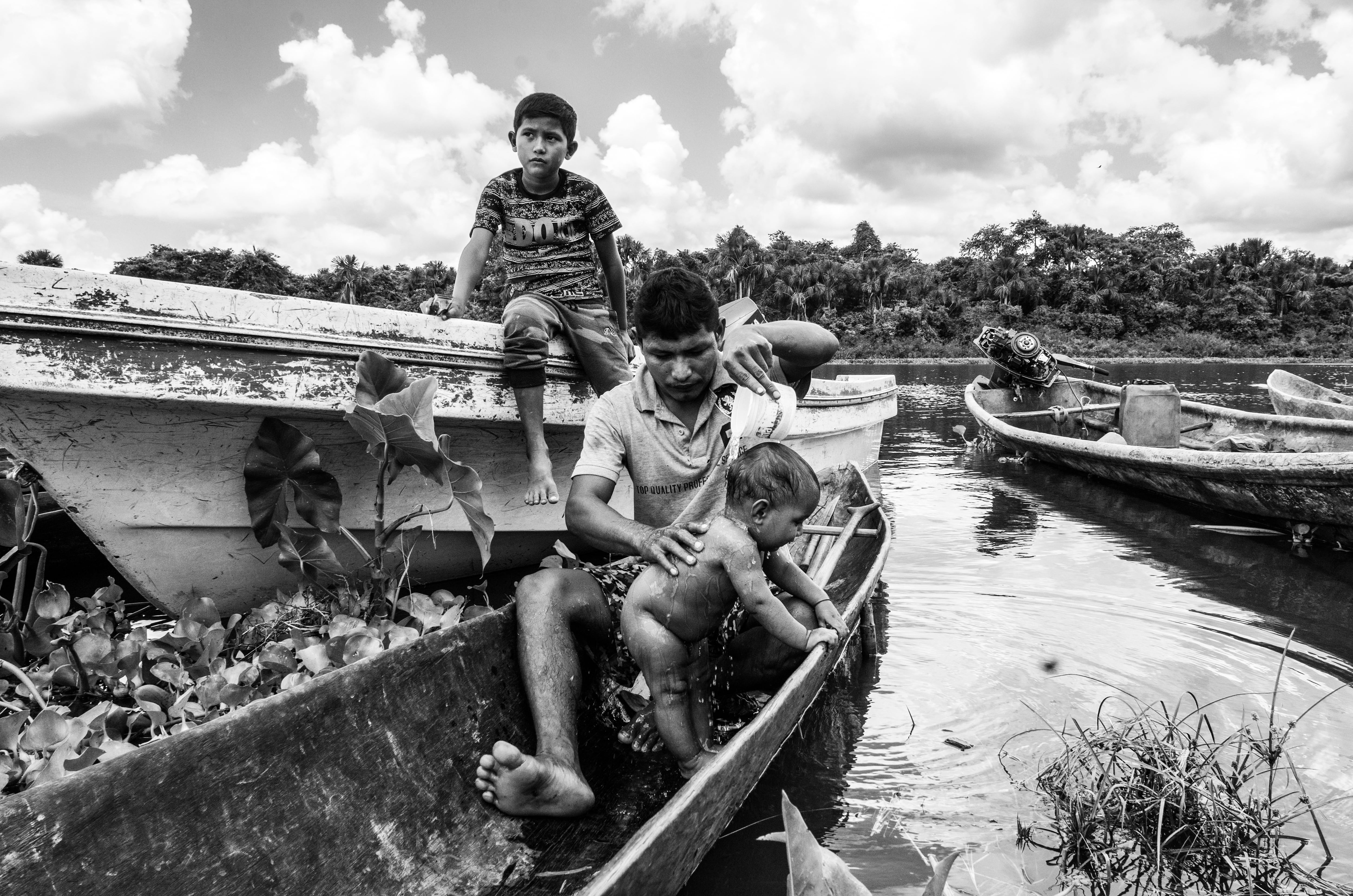 Un hombre baña a su hijo con agua del río Orinoco, en Venezuela.