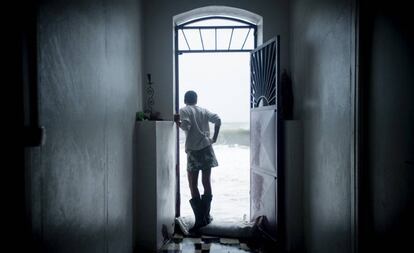 Un residente de la isla de Martinica observa las fuertes olas producidas por el huracán María desde la puerta de su casa.