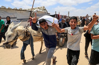 Palestinians carry aid supplies they received from the U.S.-backed Gaza Humanitarian Foundation, in Khan Younis, in the southern Gaza Strip, May 28, 2025