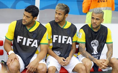 Hulk, Neymar e Dani Alves assistem ao jogo no banco de reservas do Brasil.