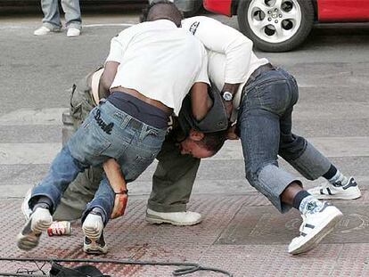 Dos amigos de la fallecida tratan de reducir al presunto asesino, Manuel Córdoba.